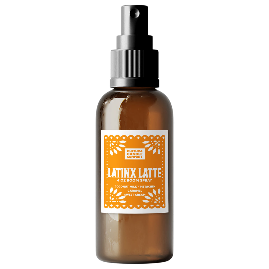 An amber glass room spray bottle with a black pump dispenser and a white label featuring orange text and decorative borders. The label reads 'LATINX LATTE' by 'Cultura Candle Company'.